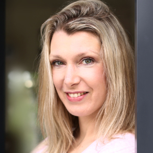 Physiotherapeutin Alexandra Groß: Eine Frau mit glattem, blondem Haar und hellen Augen lächelt in die Kamera. Sie trägt ein blassrosa Oberteil und ist in sanftem, natürlichem Licht abgebildet.